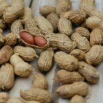 A detailed close-up of peanuts in their shells scattered on a wooden surface.